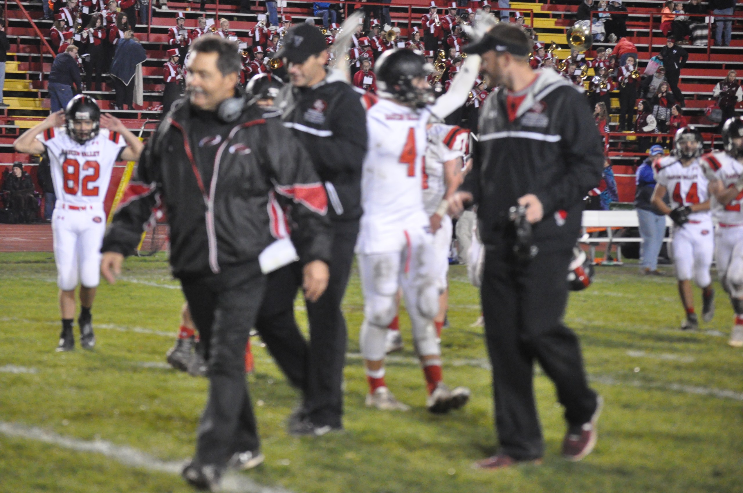 Coach Sams along with Coach Chromczak and Coach Philips with a celebrating Kory Kemmerer in the background.