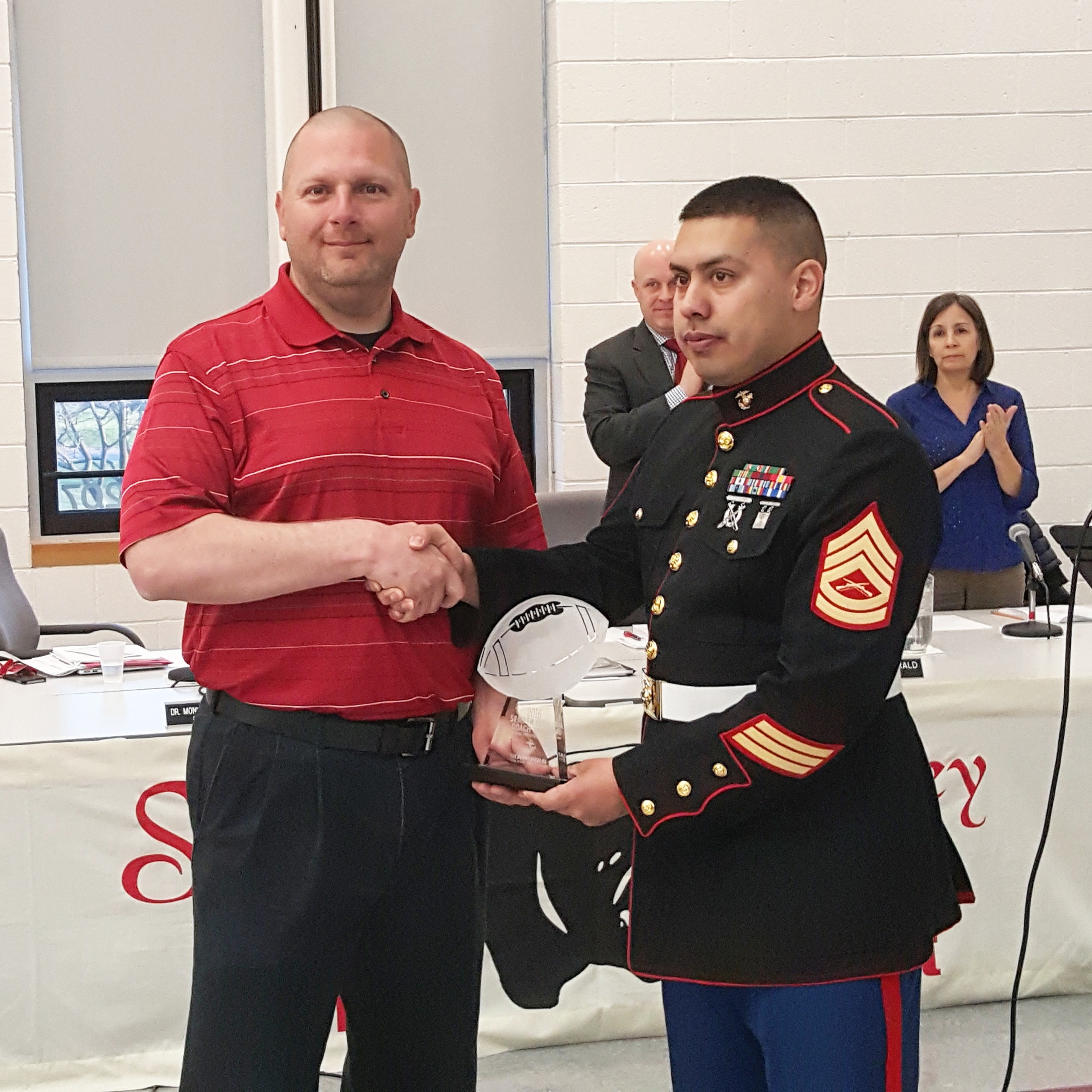 Saucon Valley football coach Matt Evancho accepts the U.S. Marine Corps Semper Fi Coach Award at the April 12, 2016 Saucon Valley School Board meeting, during a standing ovation.