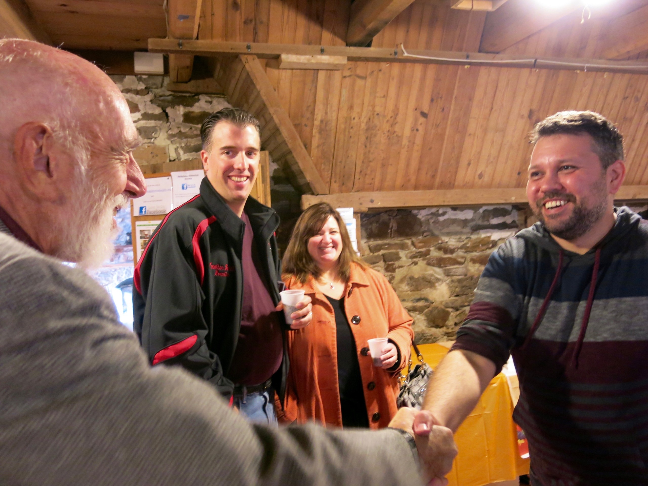 Chuck Hampton of Hellertown greets publisher Josh Popichak as Jonathan and Lesley Schultz look on.